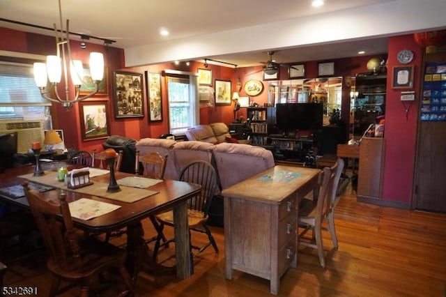 dining space featuring ceiling fan with notable chandelier, wood finished floors, rail lighting, and recessed lighting