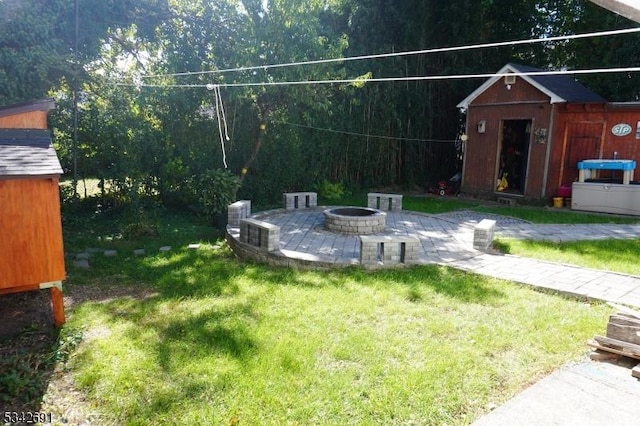 view of yard with a patio area, a shed, a fire pit, and an outdoor structure