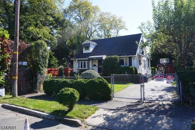 cape cod house featuring a fenced front yard and a gate