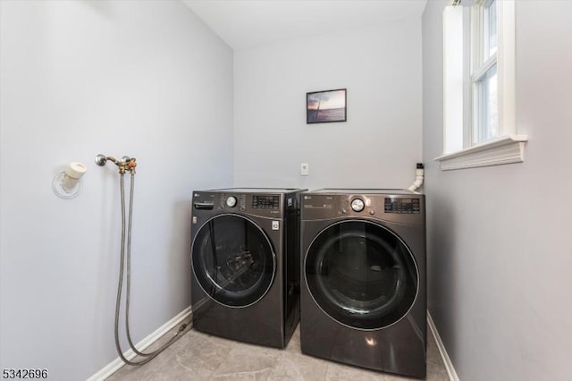 washroom featuring washer and dryer, laundry area, and baseboards