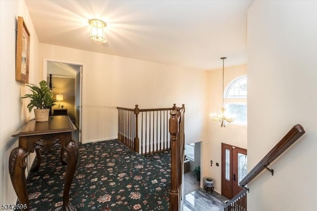 hall featuring a chandelier and carpet