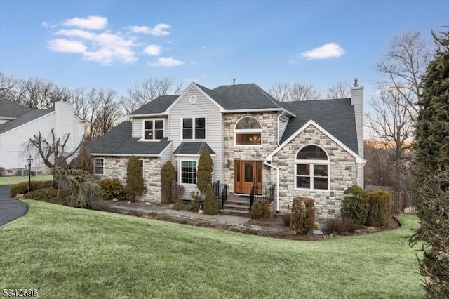 view of front of property with a front lawn, roof with shingles, a chimney, and fence