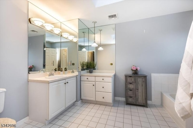 full bathroom featuring a tub to relax in, tile patterned floors, visible vents, and vanity