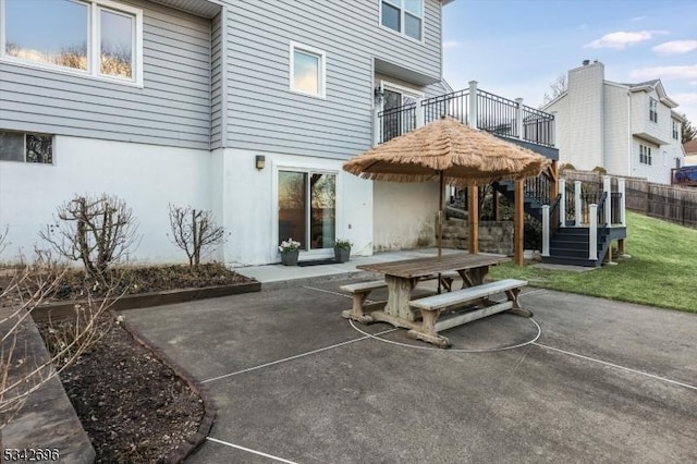 rear view of property featuring a patio area, fence, outdoor dining area, and stucco siding