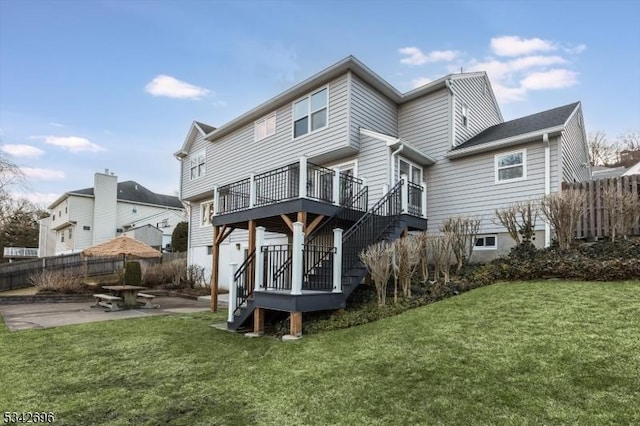 back of property with stairs, fence, a lawn, and a patio