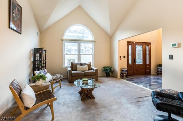 carpeted living area featuring high vaulted ceiling