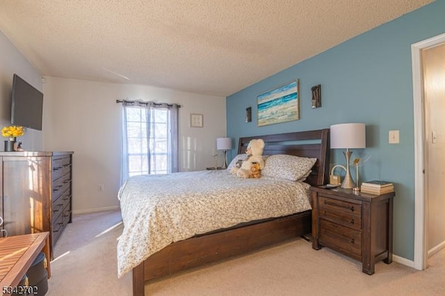 bedroom featuring baseboards, light carpet, and a textured ceiling