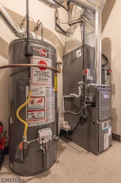 utility room with heating unit and water heater