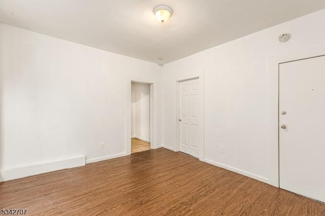 empty room with baseboards and wood finished floors