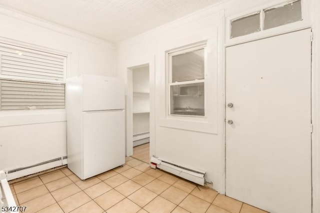 interior space with light tile patterned floors, a baseboard heating unit, and crown molding