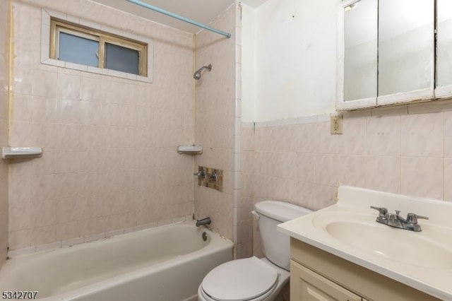 bathroom with tub / shower combination, toilet, tile walls, and vanity