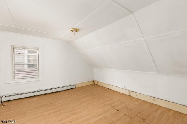 additional living space featuring a baseboard radiator, lofted ceiling, and wood finished floors