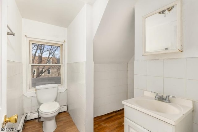 bathroom with tile walls, toilet, and wood finished floors