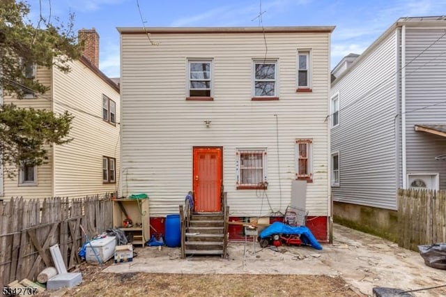 back of house with entry steps and fence