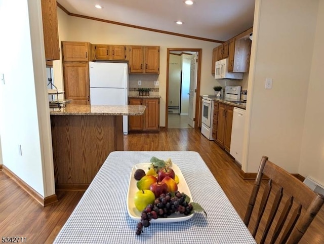 kitchen featuring vaulted ceiling, white appliances, wood finished floors, and ornamental molding