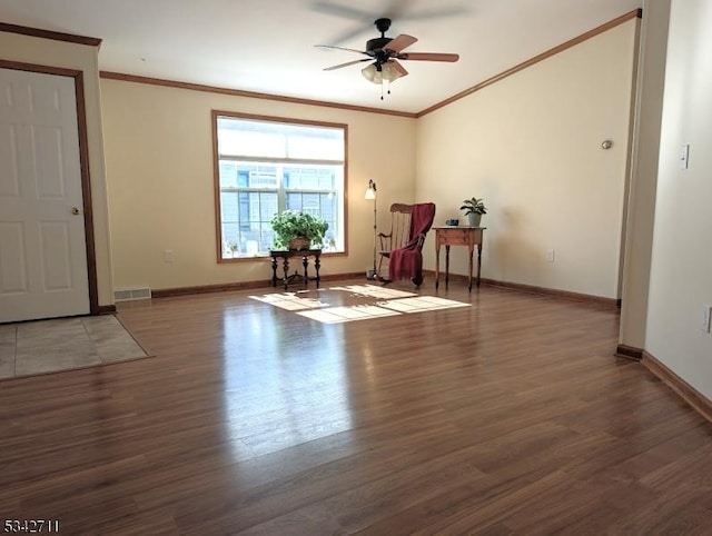 unfurnished room with baseboards, visible vents, ceiling fan, ornamental molding, and wood finished floors