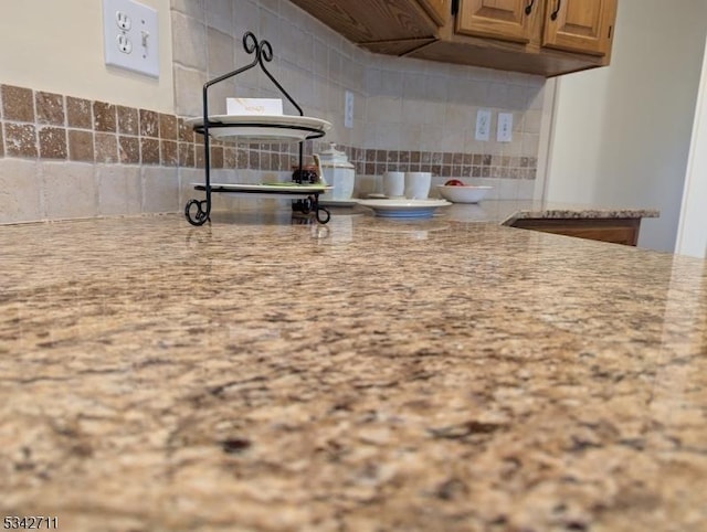 kitchen with decorative backsplash and light stone countertops