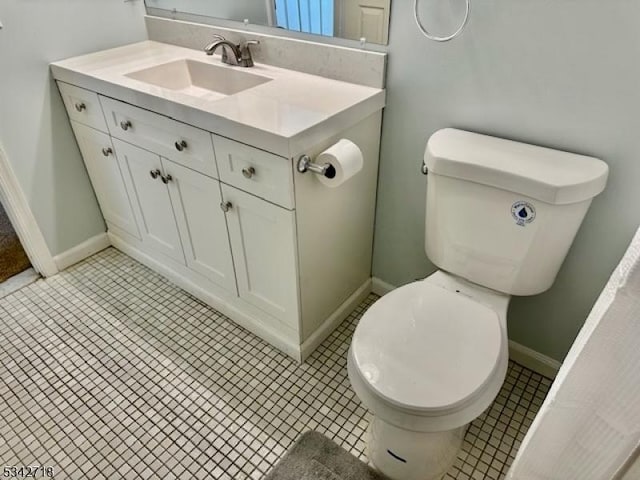 bathroom featuring vanity, toilet, and baseboards