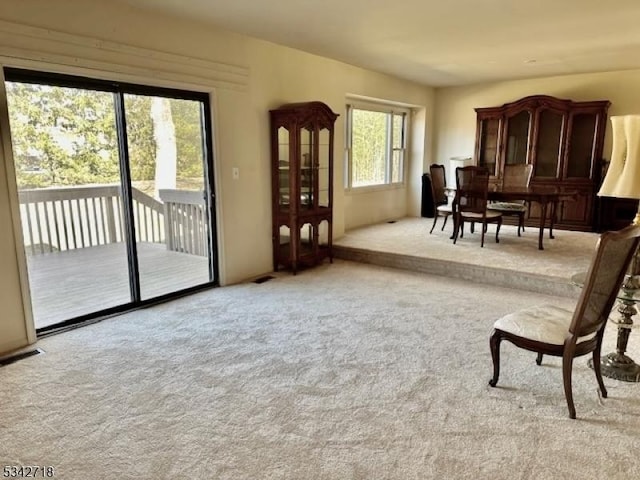 sitting room featuring visible vents and light colored carpet