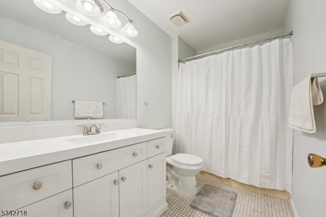 bathroom featuring tile patterned flooring, toilet, and vanity