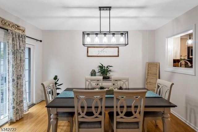 dining area featuring baseboards and light wood-style floors