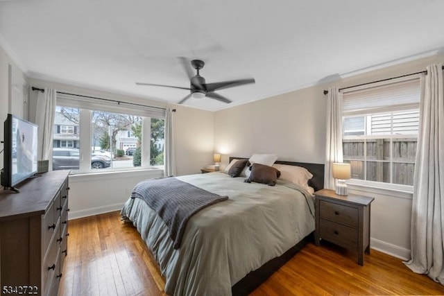 bedroom featuring ornamental molding, light wood finished floors, and baseboards