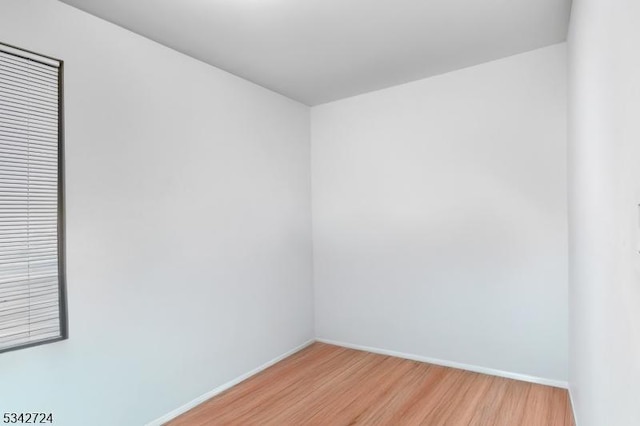 unfurnished room featuring baseboards and light wood finished floors