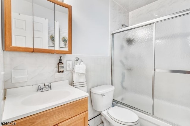 full bath featuring wainscoting, vanity, and toilet