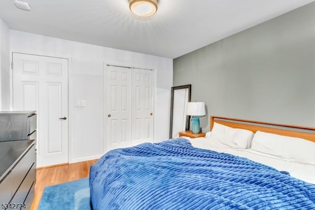 bedroom featuring a closet, wood finished floors, and baseboards