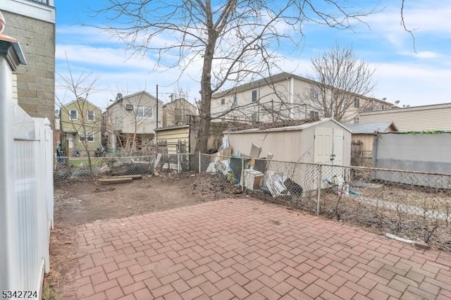 view of patio featuring a shed, fence, and an outbuilding