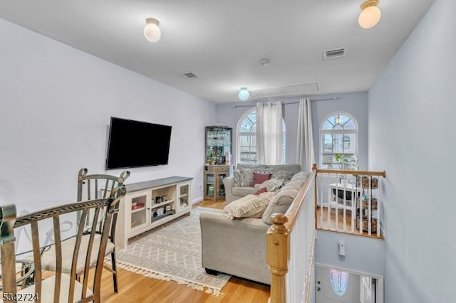 living area with visible vents and wood finished floors