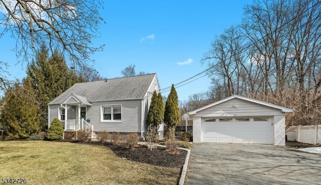 view of front of house featuring an outbuilding, a detached garage, a shingled roof, fence, and a front lawn