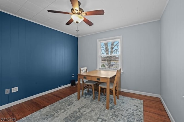 dining space featuring ornamental molding, wood finished floors, a ceiling fan, and baseboards