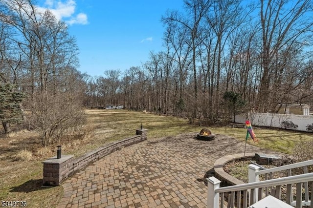 view of patio featuring fence and a fire pit