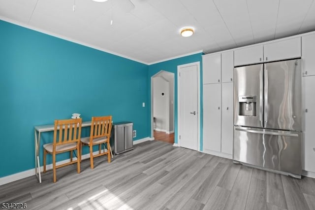 interior space with baseboards, wood finished floors, and crown molding