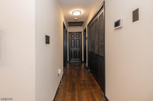 hall featuring baseboards and dark wood-style flooring