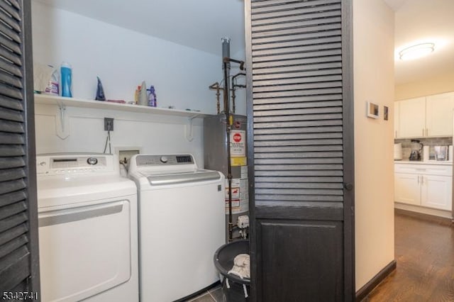 laundry area with laundry area, water heater, dark wood finished floors, and washer and dryer