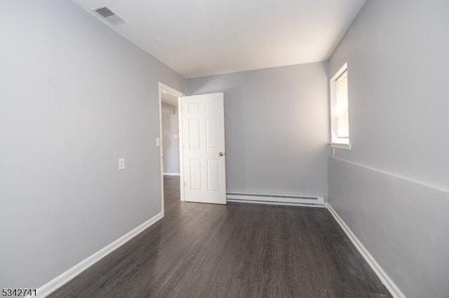 empty room with baseboards, a baseboard radiator, visible vents, and wood finished floors