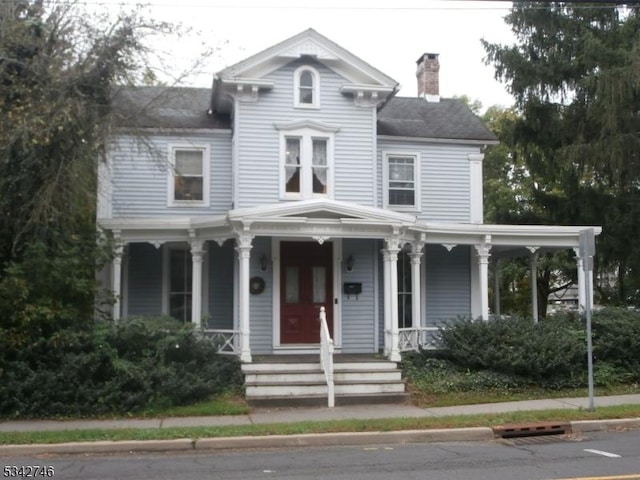 view of front of property with a porch and a chimney