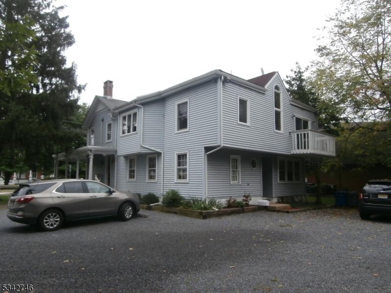 view of front facade featuring a chimney and a balcony