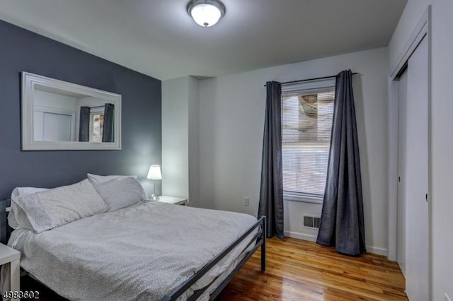 bedroom featuring visible vents, wood finished floors, and baseboards