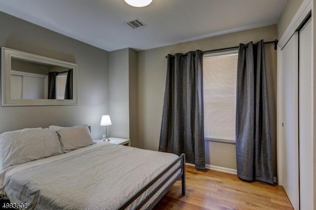 bedroom featuring visible vents, baseboards, and wood finished floors