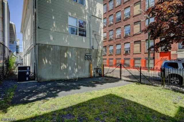 view of building exterior with cooling unit and fence