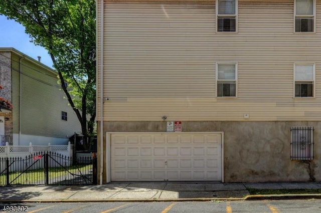 view of home's exterior with stucco siding, an attached garage, and fence