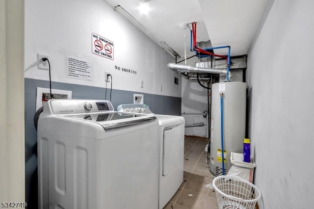 clothes washing area with washer and dryer, gas water heater, light tile patterned floors, and laundry area