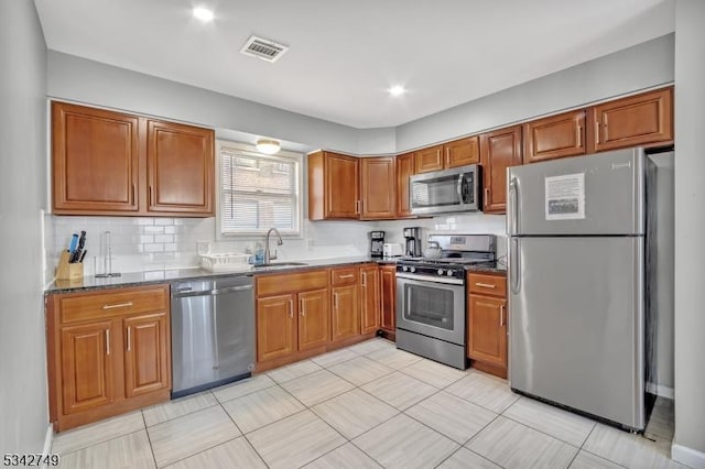 kitchen with brown cabinets, appliances with stainless steel finishes, and a sink