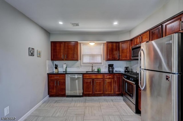 kitchen with dark countertops, visible vents, tasteful backsplash, appliances with stainless steel finishes, and a sink