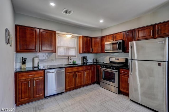 kitchen featuring visible vents, a sink, tasteful backsplash, recessed lighting, and appliances with stainless steel finishes