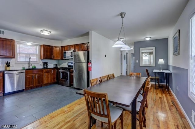 dining space with visible vents, baseboards, and light wood finished floors