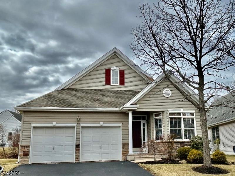 view of front of home featuring a garage, stone siding, driveway, and a shingled roof